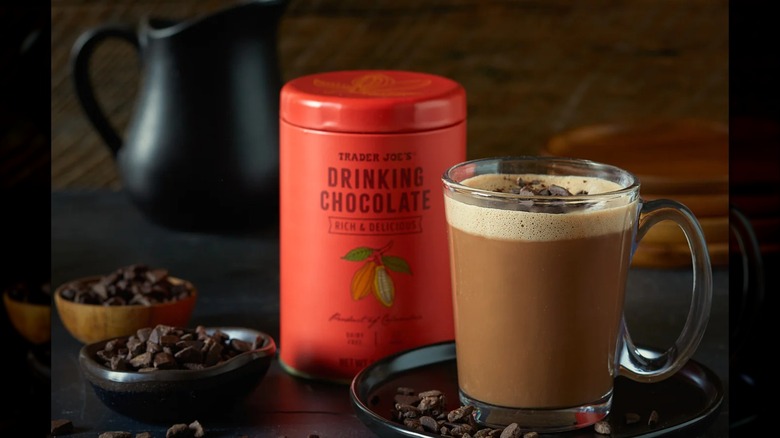 An orange can of Trader Joe's drinking chocolate next to a cup of the same