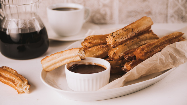a plate of churros and coffee
