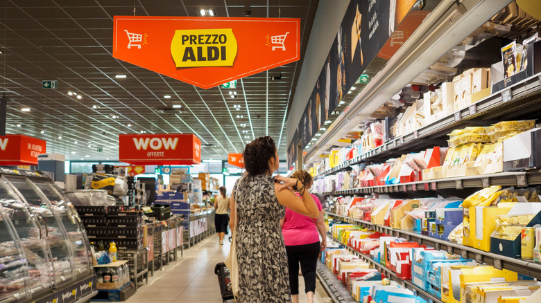 a view down an aisle at Aldi with multiple shoppers browsing the shelves