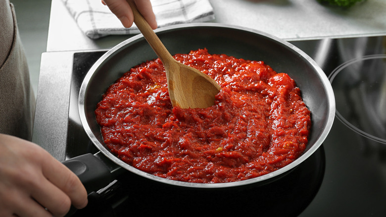 Stirring red sauce on stove